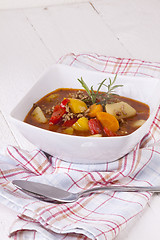 Image showing Hearty Stew in Bowl and Spoon on Plaid Dish Towel