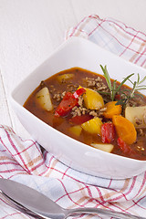 Image showing Hearty Stew in Bowl and Spoon on Plaid Dish Towel