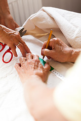 Image showing Hand Cutting Cloth with Scissors