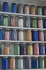 Image showing Shelving with glass jars of colorful pigments