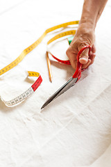 Image showing Hand Cutting Cloth with Scissors