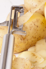 Image showing Potatoes with Peeler and Peeled Skin