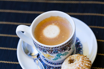 Image showing Cup of freshly brewed tea and a cookie