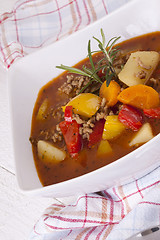 Image showing Hearty Stew in Bowl and Spoon on Plaid Dish Towel