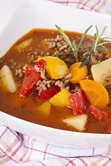 Image showing Hearty Stew in Bowl and Spoon on Plaid Dish Towel