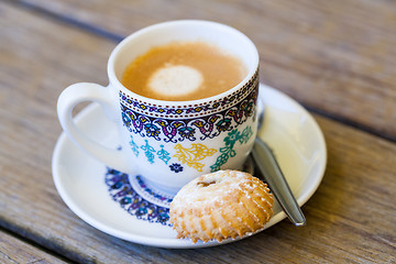 Image showing Cup of freshly brewed tea and a cookie