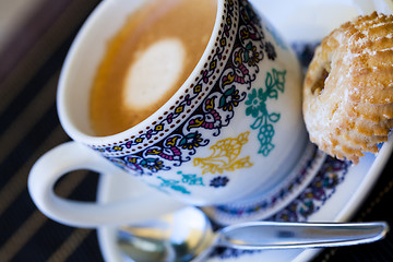 Image showing Cup of freshly brewed tea and a cookie