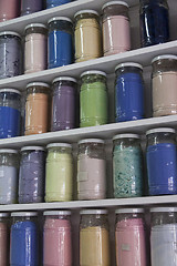 Image showing Shelving with glass jars of colorful pigments