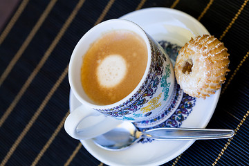 Image showing Cup of freshly brewed tea and a cookie