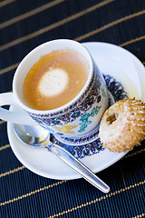 Image showing Cup of freshly brewed tea and a cookie