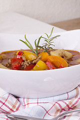 Image showing Hearty Stew in Bowl and Spoon on Plaid Dish Towel