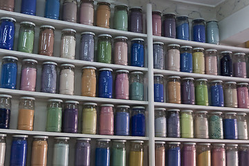 Image showing Shelving with glass jars of colorful pigments