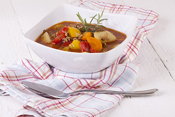 Image showing Hearty Stew in Bowl and Spoon on Plaid Dish Towel