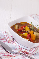 Image showing Hearty Stew in Bowl and Spoon on Plaid Dish Towel