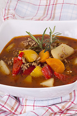 Image showing Hearty Stew in Bowl and Spoon on Plaid Dish Towel