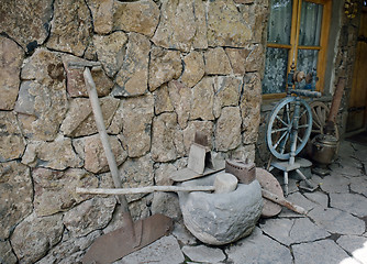 Image showing ancient tools and everyday objects next to the wall 