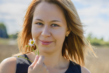 Image showing Portrait of young female with camomile