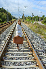 Image showing Young girl with suitcase at railways
