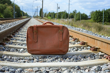 Image showing Vintage brown suitcase on the railway