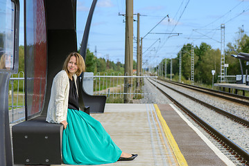 Image showing Young girl sitting on the railway station