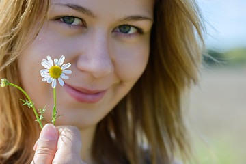 Image showing Portrait of young woman with camomile