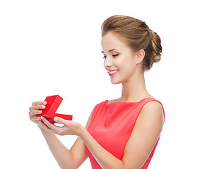 Image showing smiling young woman in red dress with gift box