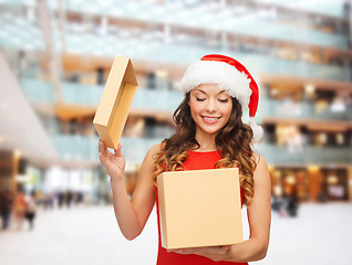 Image showing smiling woman in santa helper hat with gift box