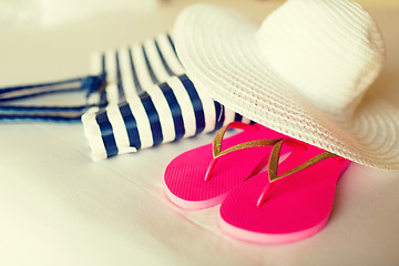 Image showing close-up of beach bag, hat and flip-flops on bed