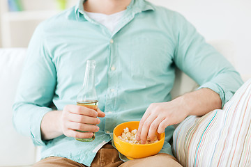 Image showing close up of man with popcorn and beer at home