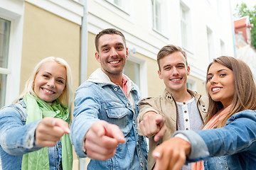 Image showing group of smiling friends in city pointing finger