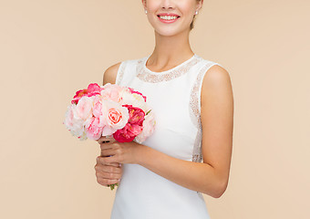 Image showing smiling woman in white dress with bouquet of roses