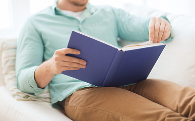 Image showing close up of man reading book at home