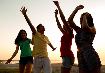 Image showing smiling friends dancing on summer beach