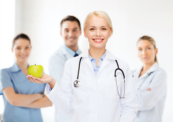 Image showing smiling female doctor with green apple