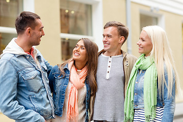 Image showing group of smiling friends walking in the city