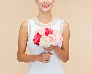 Image showing smiling woman in white dress with bouquet of roses