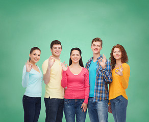 Image showing group of smiling teenagers over green board