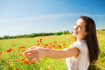 Image showing smiling young woman on poppy field