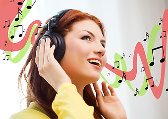 Image showing smiling young girl in headphones at home