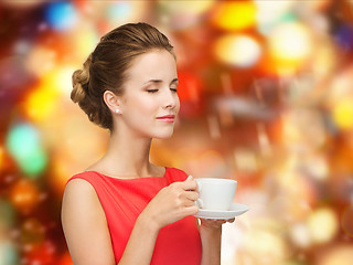 Image showing smiling woman in red dress with cup of coffee