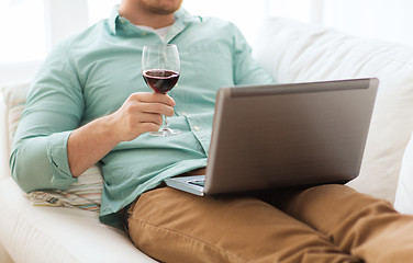 Image showing close up of man with laptop and wine glass