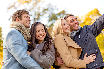 Image showing group of smiling men and women in autumn park