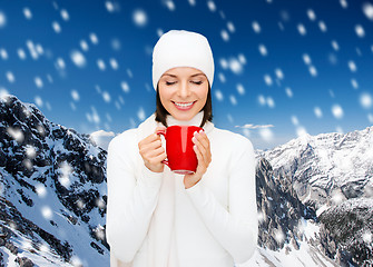 Image showing smiling young woman in winter clothes with cup