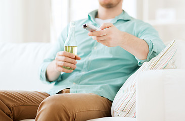 Image showing man with beer and remote control at home