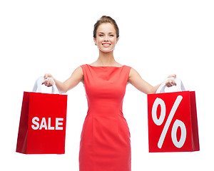 Image showing young woman in red dress with shopping bags