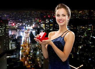 Image showing smiling woman holding red gift box