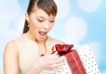 Image showing smiling woman in red dress with gift box