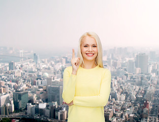 Image showing smiling woman pointing her finger up