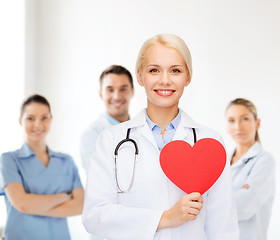 Image showing smiling female doctor with heart and stethoscope