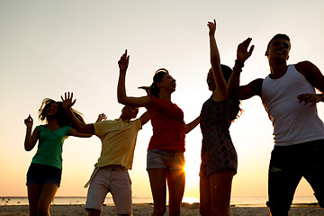 Image showing smiling friends dancing on summer beach